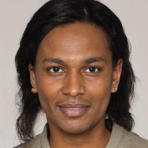 Joyful black adult male with medium  brown hair and brown eyes
