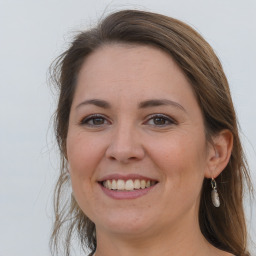 Joyful white adult female with long  brown hair and brown eyes