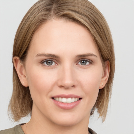 Joyful white young-adult female with medium  brown hair and grey eyes