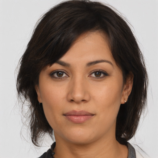 Joyful latino young-adult female with medium  brown hair and brown eyes