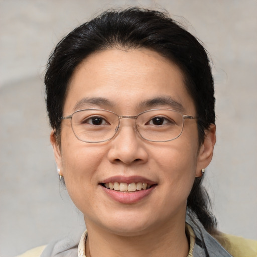 Joyful asian adult female with medium  brown hair and brown eyes