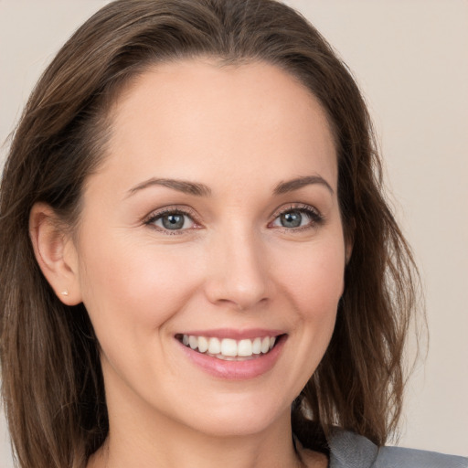 Joyful white young-adult female with long  brown hair and grey eyes