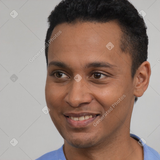 Joyful black young-adult male with short  black hair and brown eyes