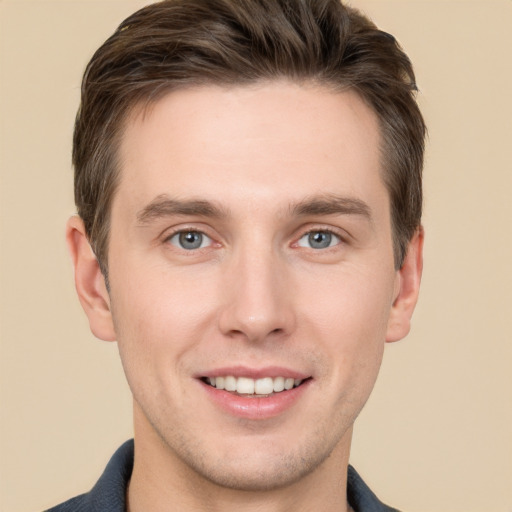 Joyful white young-adult male with short  brown hair and grey eyes