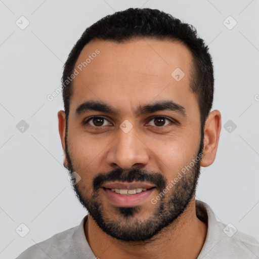 Joyful latino young-adult male with short  black hair and brown eyes