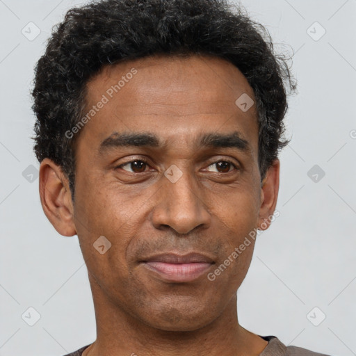 Joyful black adult male with short  black hair and brown eyes