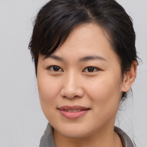 Joyful asian young-adult female with medium  brown hair and brown eyes