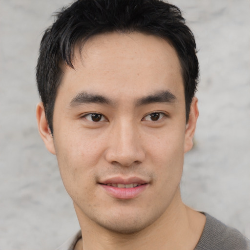 Joyful asian young-adult male with short  black hair and brown eyes