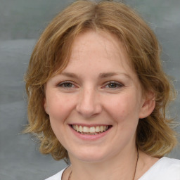 Joyful white young-adult female with medium  brown hair and blue eyes