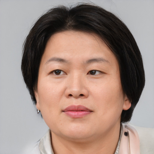 Joyful asian adult female with medium  brown hair and brown eyes
