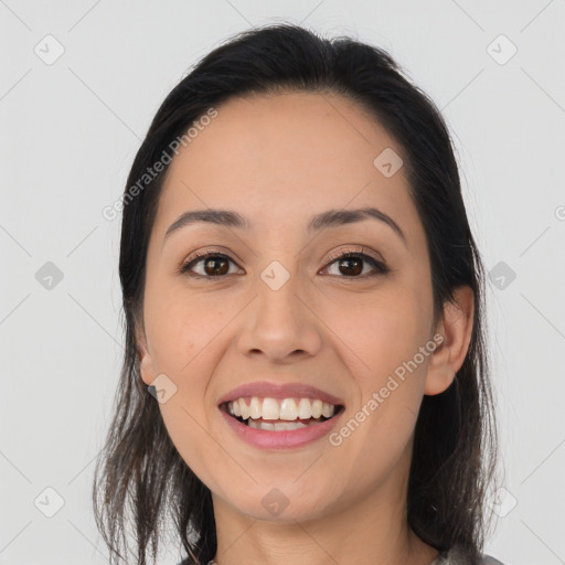 Joyful latino young-adult female with long  brown hair and brown eyes