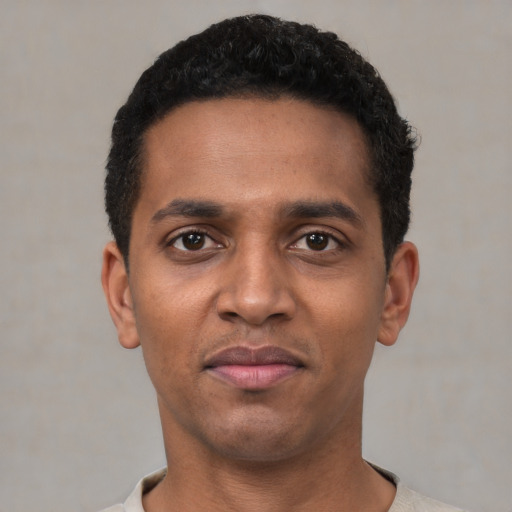 Joyful black young-adult male with short  black hair and brown eyes