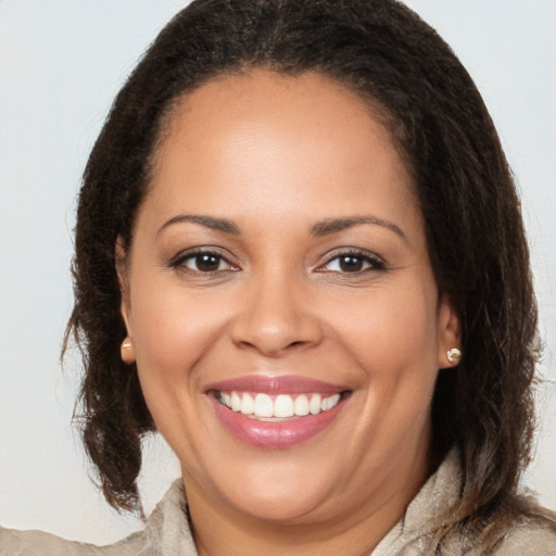 Joyful latino young-adult female with long  brown hair and brown eyes