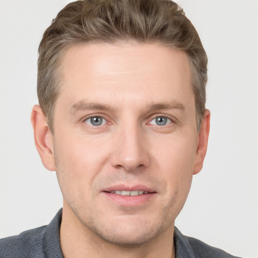 Joyful white adult male with short  brown hair and grey eyes