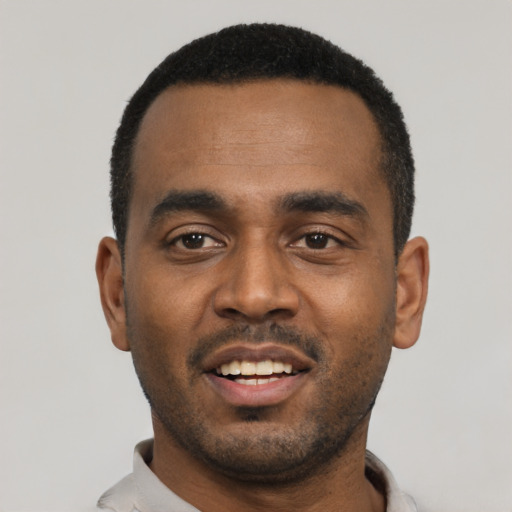 Joyful black young-adult male with short  black hair and brown eyes