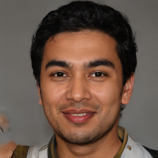 Joyful latino young-adult male with short  black hair and brown eyes
