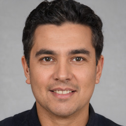 Joyful white young-adult male with short  black hair and brown eyes
