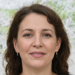 Joyful white adult female with long  brown hair and grey eyes