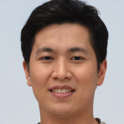 Joyful asian young-adult male with short  brown hair and brown eyes