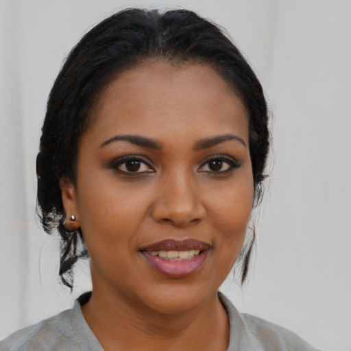 Joyful black young-adult female with long  brown hair and brown eyes