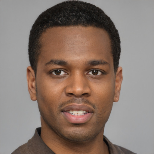 Joyful black young-adult male with short  brown hair and brown eyes