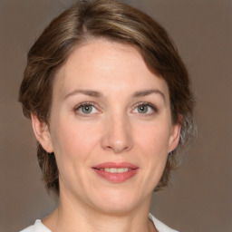 Joyful white adult female with medium  brown hair and grey eyes