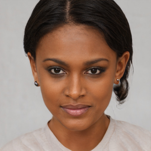 Joyful black young-adult female with medium  brown hair and brown eyes