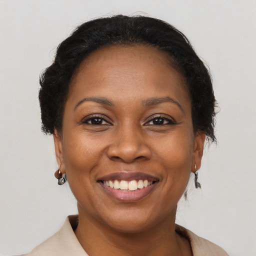 Joyful black adult female with short  brown hair and brown eyes