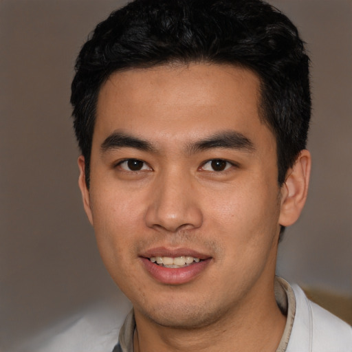 Joyful asian young-adult male with short  black hair and brown eyes