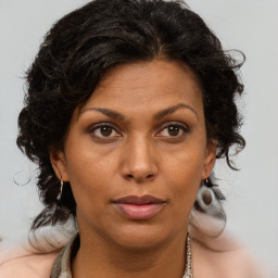 Joyful black adult female with medium  brown hair and brown eyes