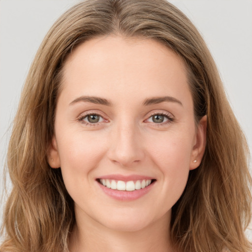 Joyful white young-adult female with long  brown hair and green eyes