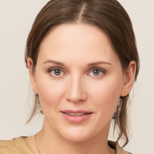 Joyful white young-adult female with medium  brown hair and grey eyes