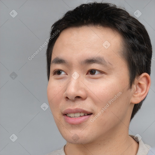 Joyful asian young-adult male with short  black hair and brown eyes