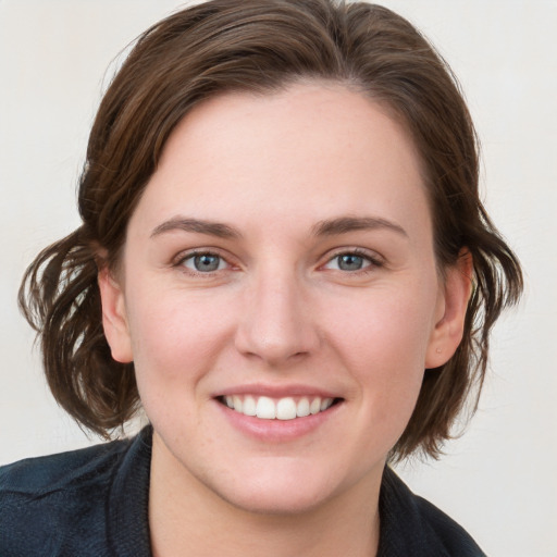 Joyful white young-adult female with medium  brown hair and blue eyes