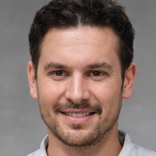 Joyful white adult male with short  brown hair and brown eyes