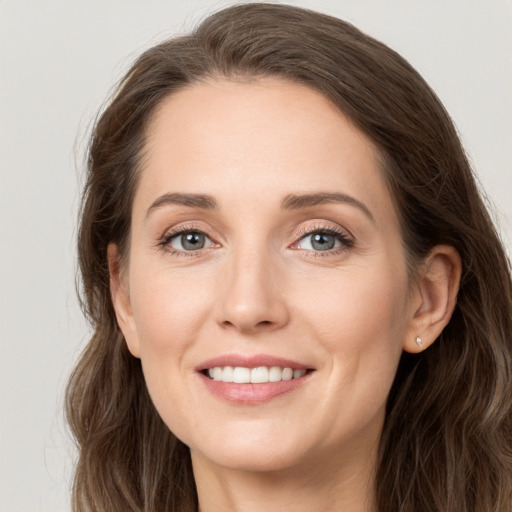 Joyful white young-adult female with long  brown hair and grey eyes