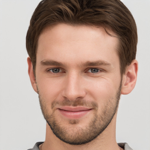 Joyful white young-adult male with short  brown hair and grey eyes