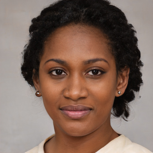 Joyful black young-adult female with long  black hair and brown eyes