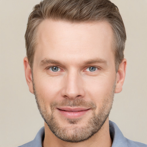 Joyful white young-adult male with short  brown hair and grey eyes