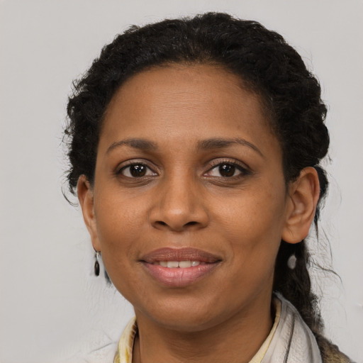 Joyful black young-adult female with long  brown hair and brown eyes