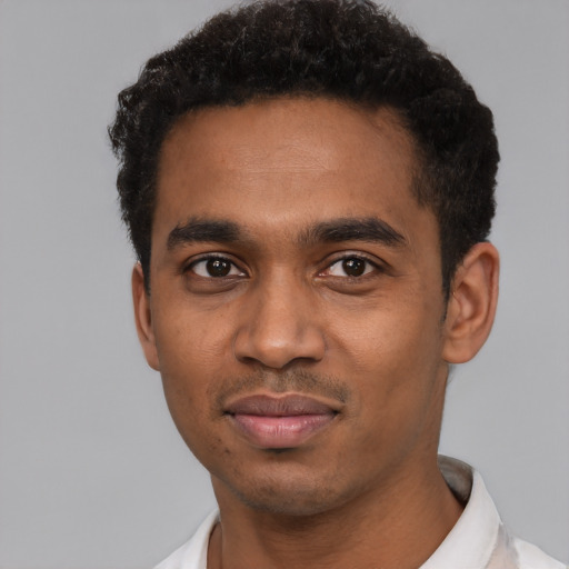 Joyful black young-adult male with short  black hair and brown eyes