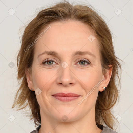 Joyful white adult female with medium  brown hair and grey eyes