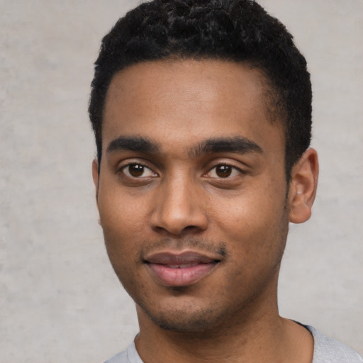 Joyful black young-adult male with short  black hair and brown eyes