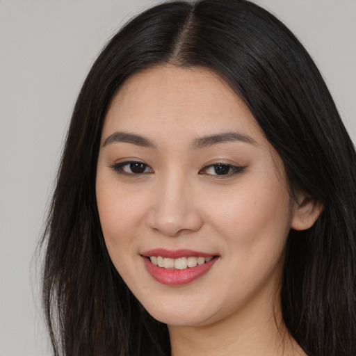 Joyful asian young-adult female with long  brown hair and brown eyes