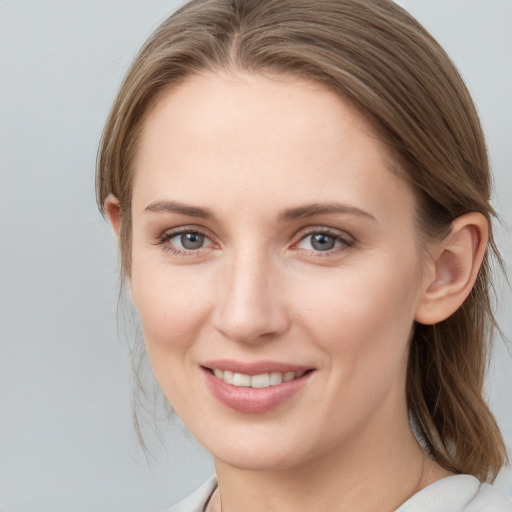 Joyful white young-adult female with medium  brown hair and grey eyes