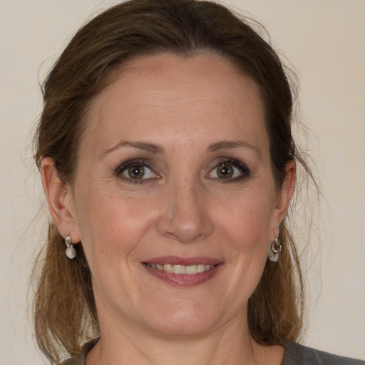 Joyful white adult female with medium  brown hair and grey eyes