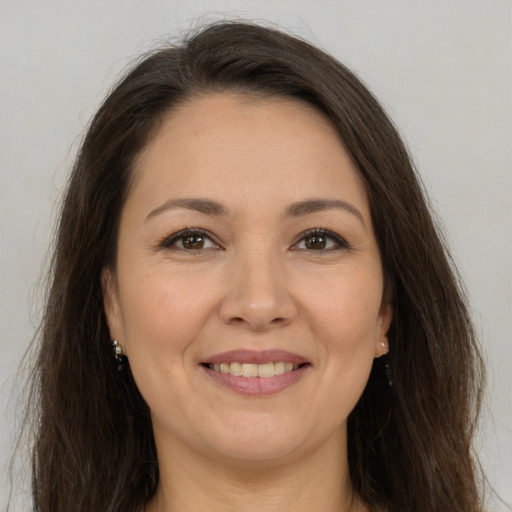 Joyful white adult female with long  brown hair and brown eyes