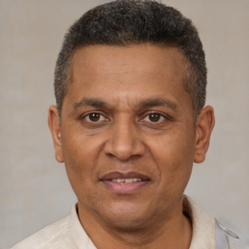 Joyful black adult male with short  brown hair and brown eyes
