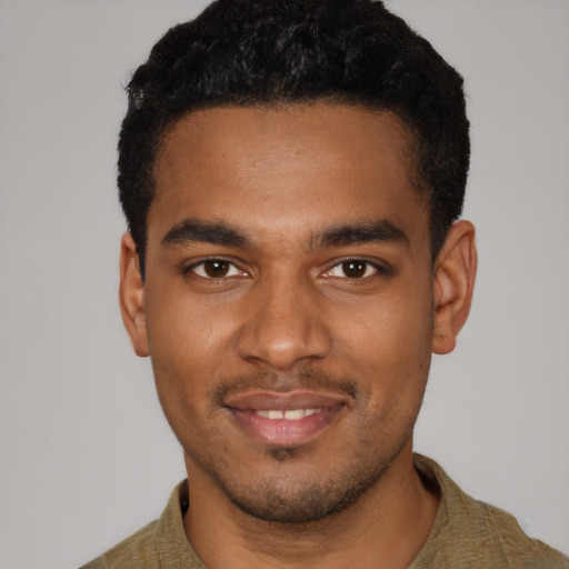 Joyful black young-adult male with short  black hair and brown eyes