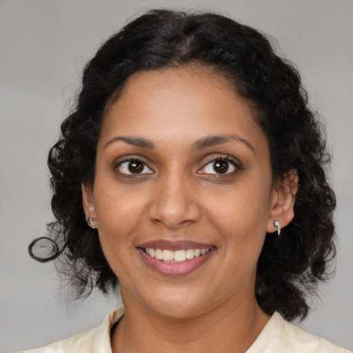 Joyful black young-adult female with medium  brown hair and brown eyes